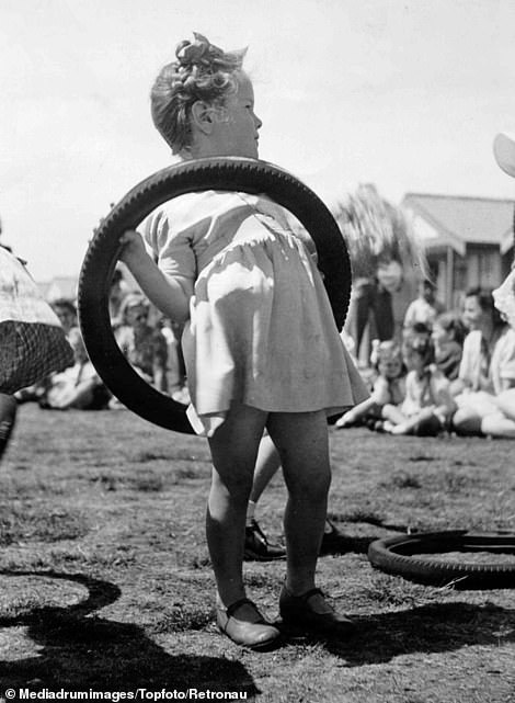 A young competitor in the children's obstacle race has difficulty with an old motor tyre at the holiday camp